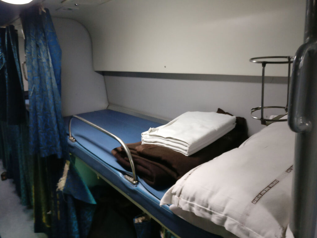 Indian Railway sleeper train interior with bedsheet and pillow